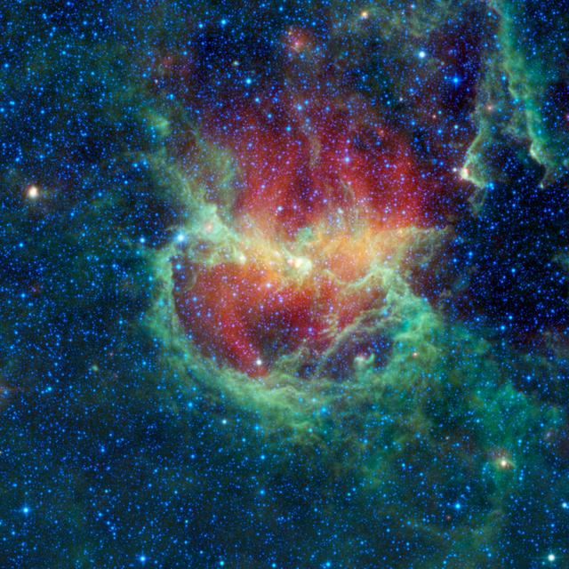 Lambda Centauri nebula as seen by the Wide-Field Infrared Survey Explorer. A green smoke-like ring encircles a central red flame against a background of dark blues and blacks. The green color traces the warm, smog-like dust while the red shows the cooler, metallic dust grains.