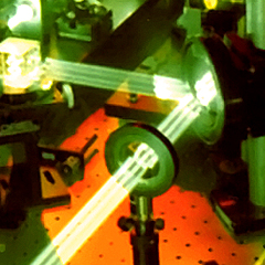 Parallel beams of pale green laser light reflect off a mirror, bouncing off at a ninety degree angle