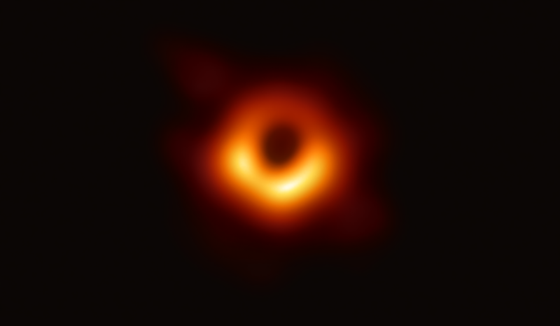 The darkness at the heart of this bright orange ring of light marks the shadow of a black hole in this shining, slightly ominous image